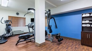 A gym with exercise equipment, a clock, and a blue wall. - Comfort Inn & Suites McComb (McComb)