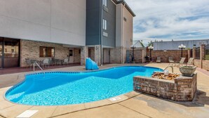 A swimming pool with a brick border, lounge chairs, and a covered seating area. - Comfort Inn & Suites McComb (McComb)