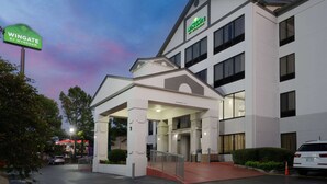 A Wingate by Wyndham hotel with a covered entrance, multiple floors, and a parking area. - Wingate by Wyndham Memphis East (Memphis)