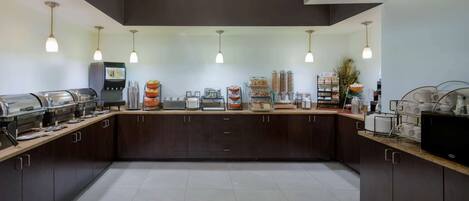 A modern kitchen with dark cabinets, a central island, and various appliances.