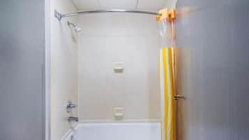 Un baño con ducha, bañera y cortina de baño a rayas amarillas y blancas.