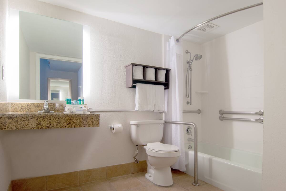 A bathroom with a toilet, sink, and shower.