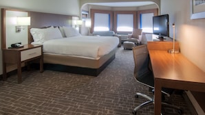 A hotel room with a large bed, a desk, a chair, and a television. - Holiday Inn Express Hotel & Suites Spence Lane by IHG (Nashville)