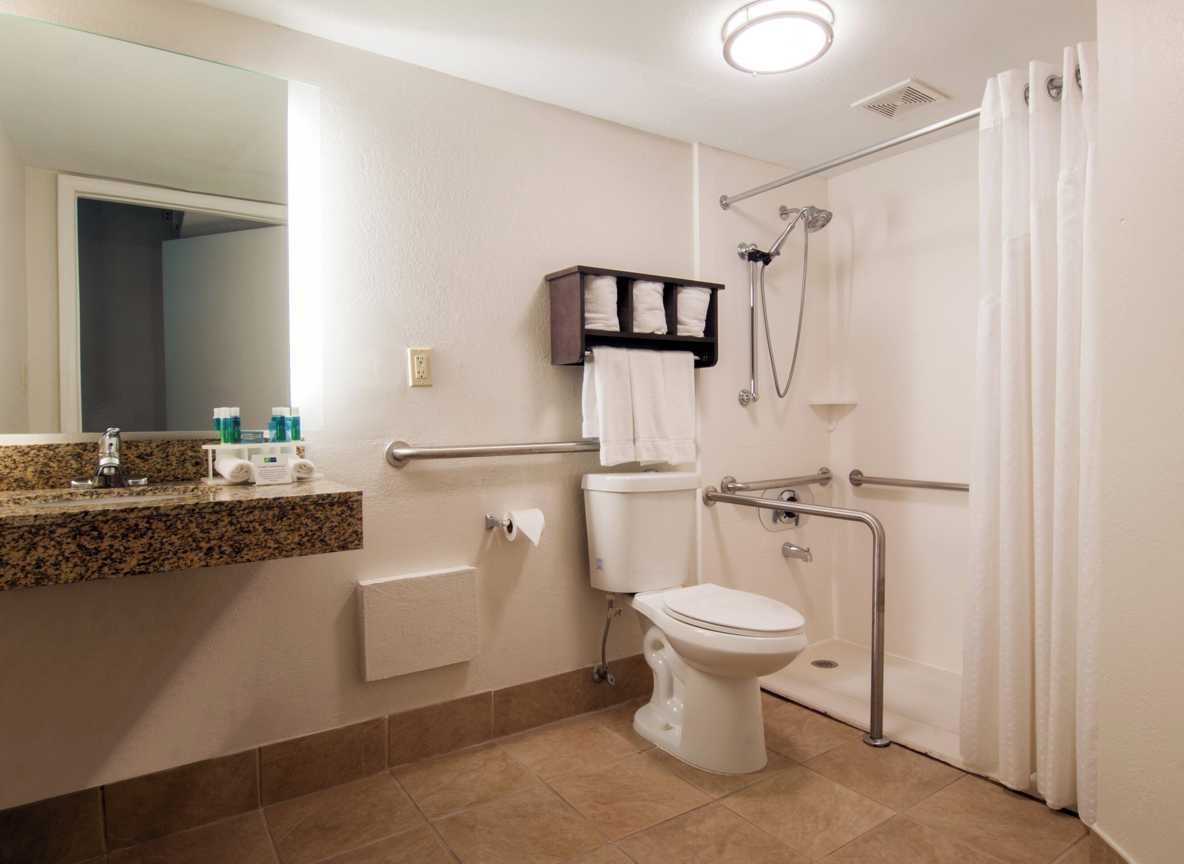 A bathroom with a toilet, sink, and shower.