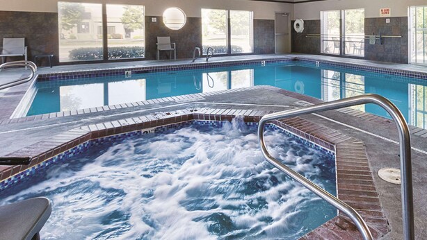 A swimming pool with a hot tub area, a sunlit room with a view, and a no diving sign. - La Quinta Inn & Suites by Wyndham Portland NW (Portland)