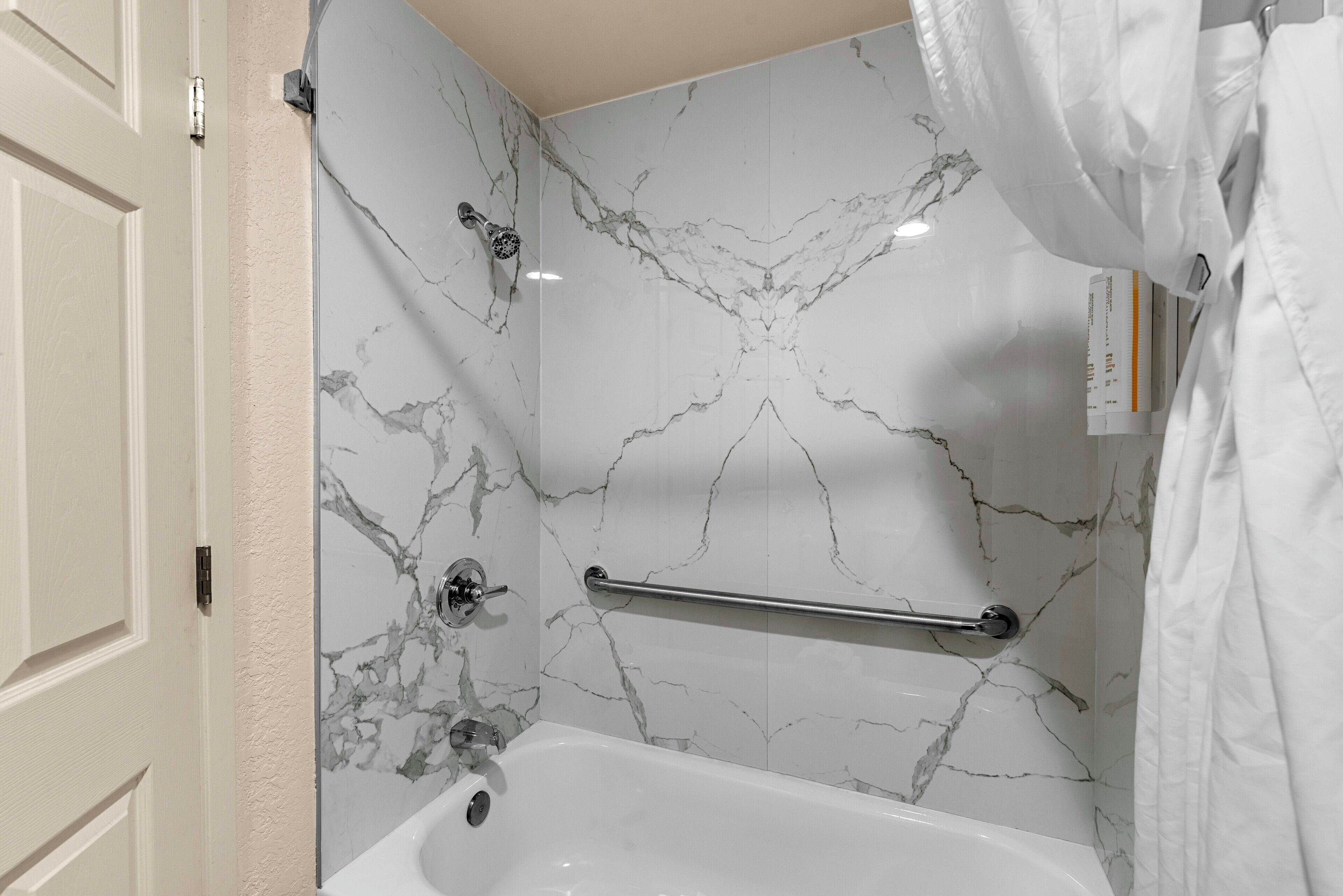 Un bagno con una vasca, un portasciugamani e una tenda da doccia.