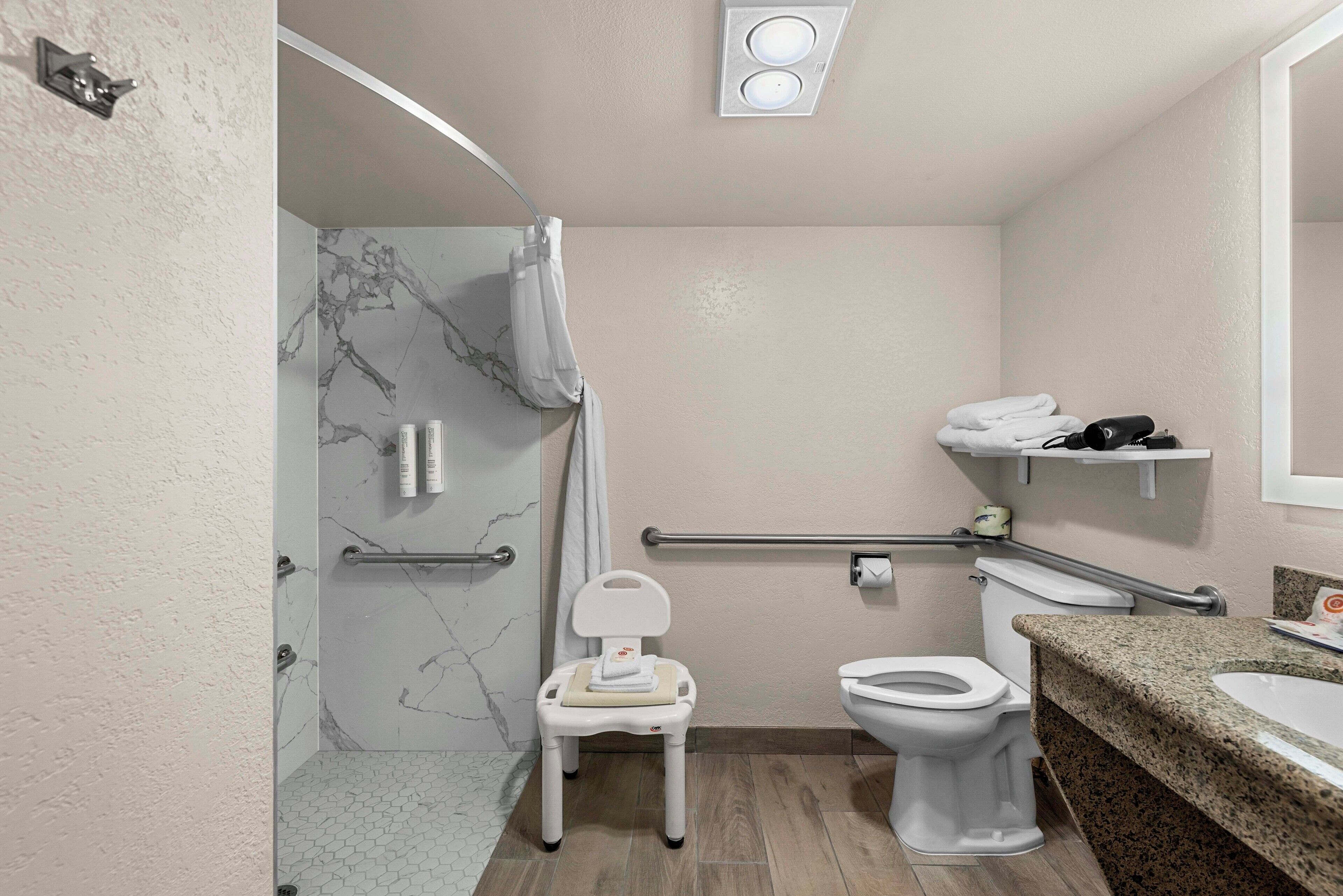 Une salle de bain équipée d’une douche, de toilettes et d’un meuble-lavabo avec un évier.