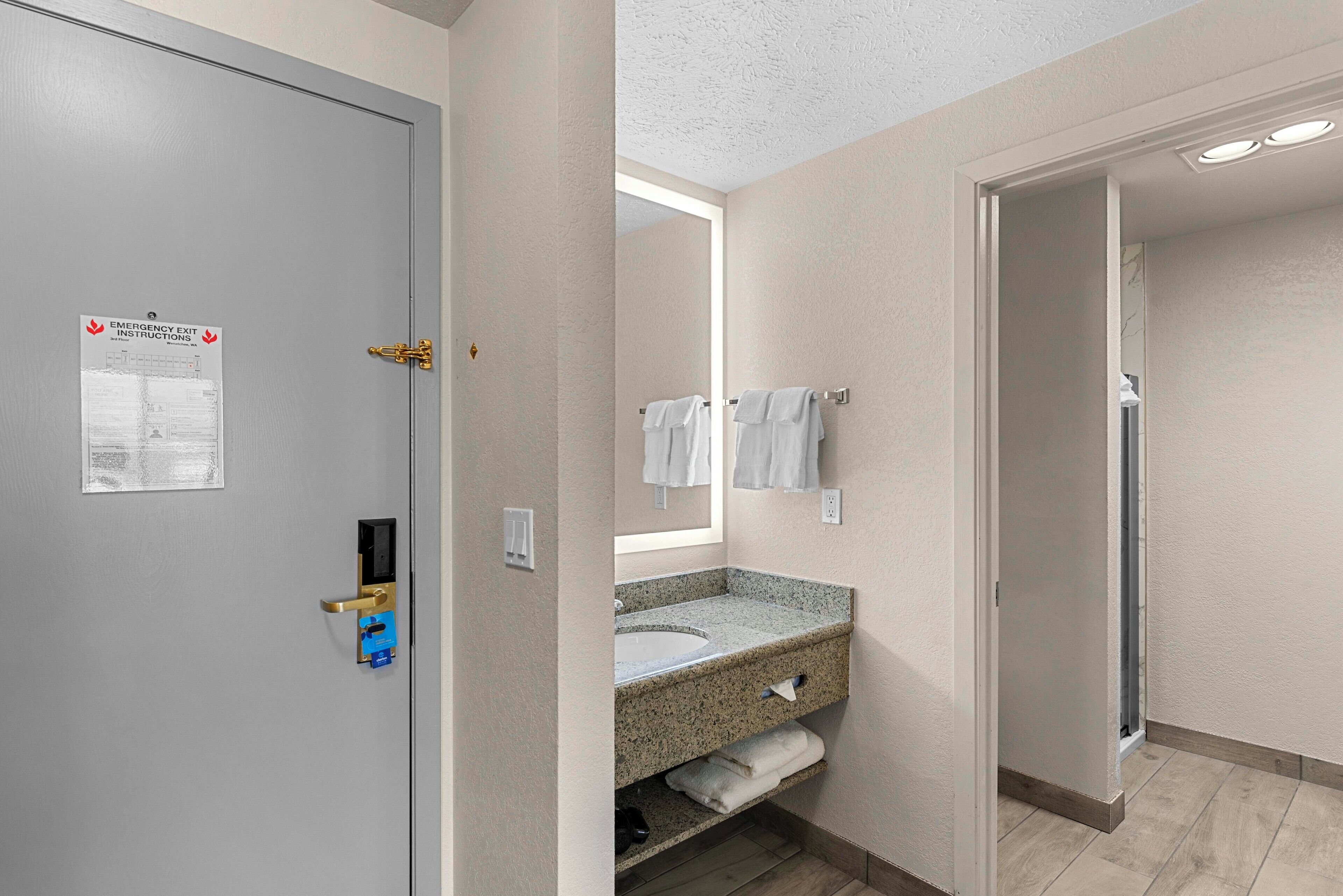 A bathroom with a sink, mirror, and towel rack.