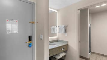 A bathroom with a sink, mirror, and towel rack.
