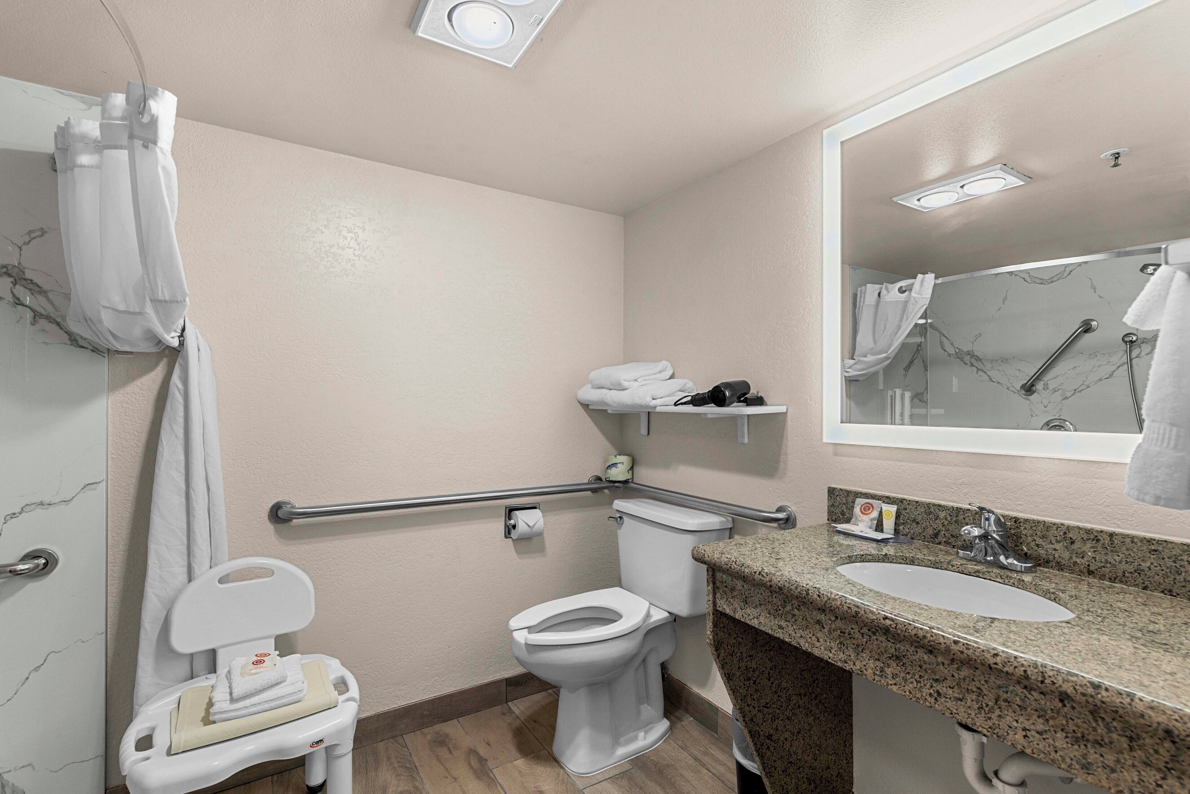 A bathroom with a toilet, sink, and shower area.
