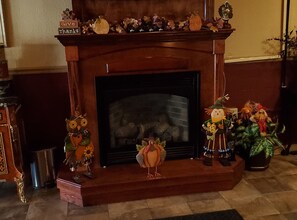 A fireplace with a mantel decorated with seasonal ornaments and figurines.