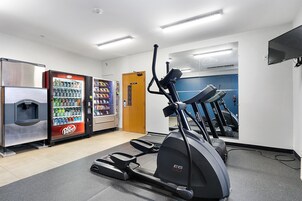 A gym with treadmills, a stationary bike, and a Dr. Pepper vending machine.