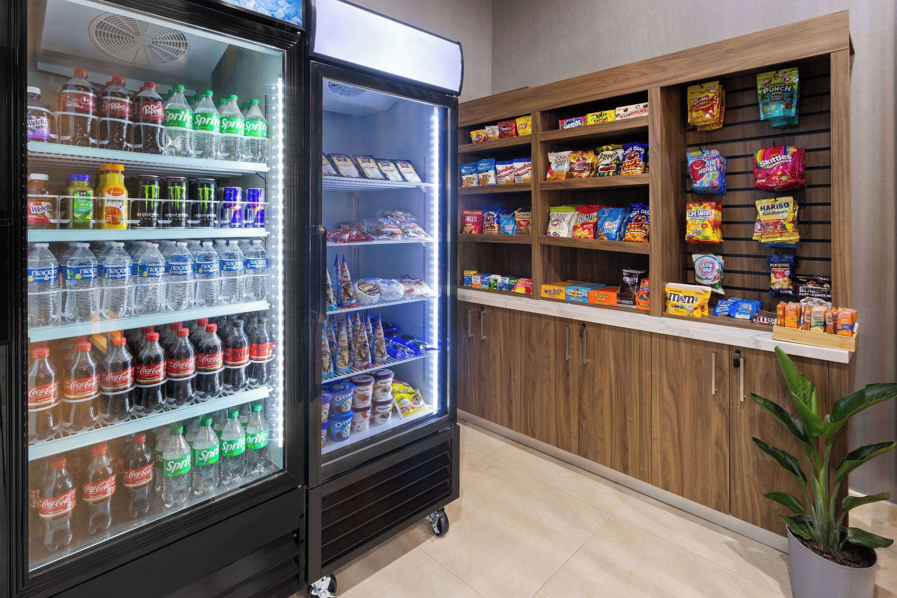 Máquina expendedora llena de diversas bebidas y aperitivos, como refrescos y papas fritas.