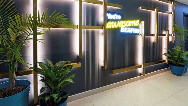 A reception area with a neon sign that reads "You're awesome." There are potted plants and a modern wall design. - La Quinta Inn & Suites by Wyndham Memphis I-240 (Memphis)