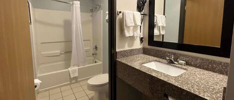 A bathroom with a shower, toilet, and sink.