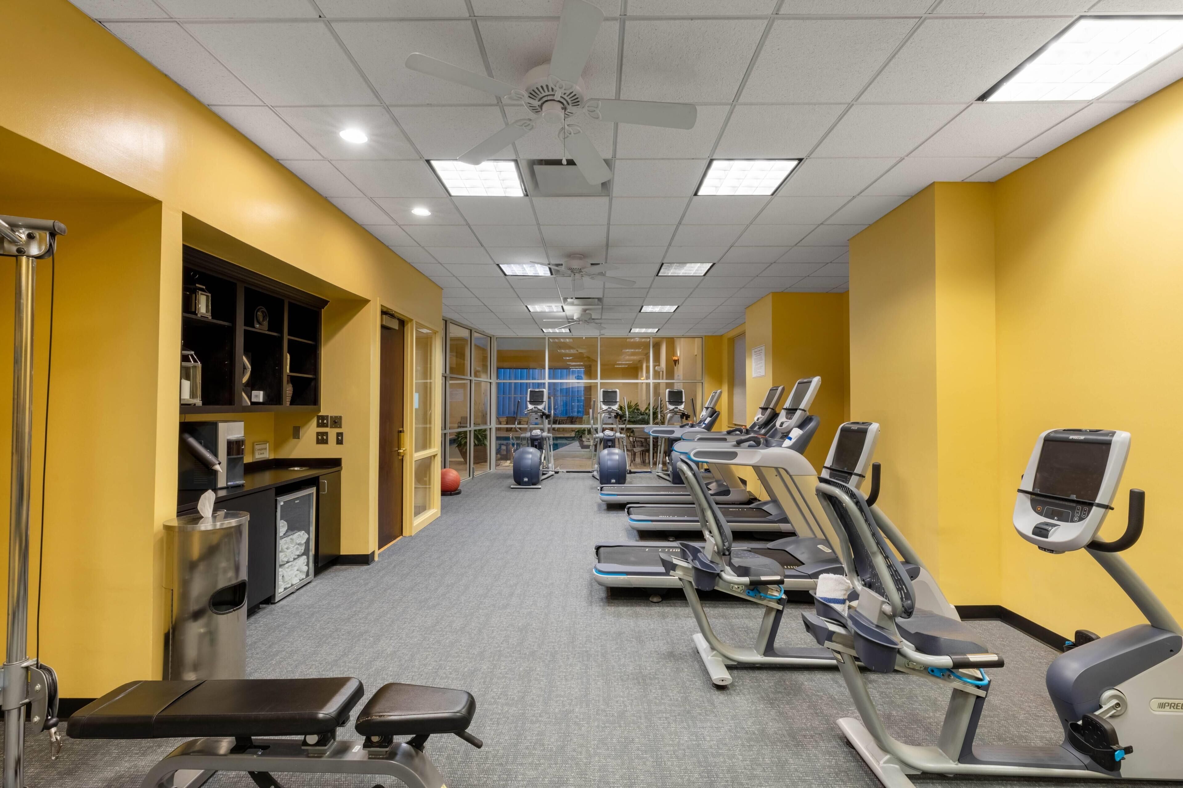 A gym with treadmills, elliptical machines, and weightlifting equipment.