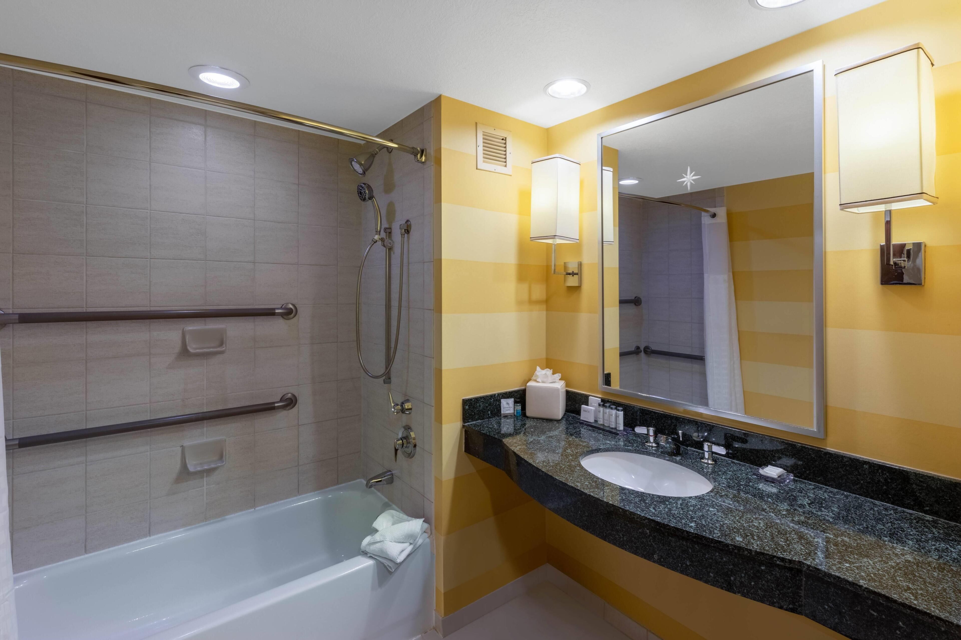 Une salle de bain équipée d’une douche, d’une baignoire, d’un lavabo et d’un miroir.