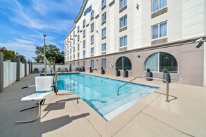 Una piscina al aire libre, tumbonas
