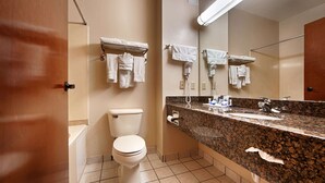 Une salle de bain équipée de toilettes, d’un lavabo et de porte-serviettes.