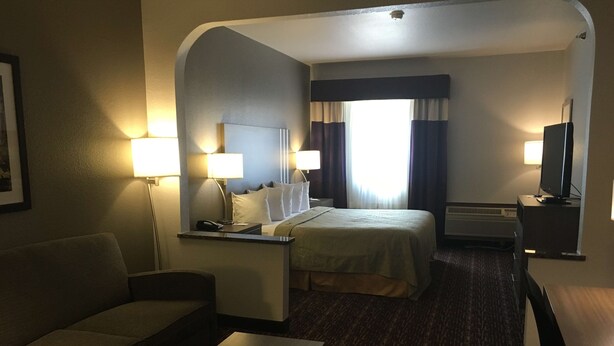 Une chambre d’hôtel équipée d’un lit, d’un bureau, d’une chaise, d’un canapé et d’une télévision.