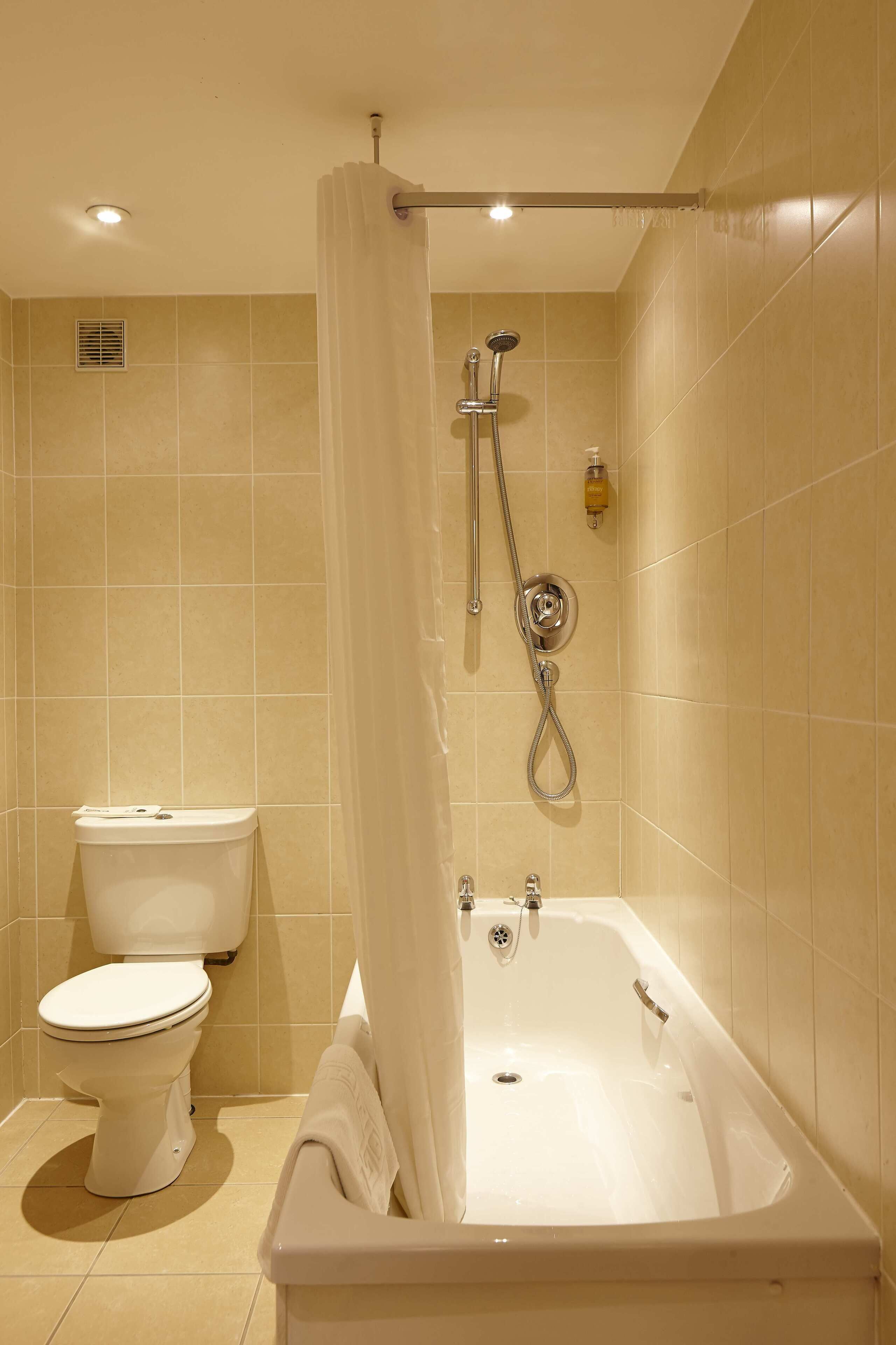 Une salle de bain avec une baignoire, des toilettes et une douche.