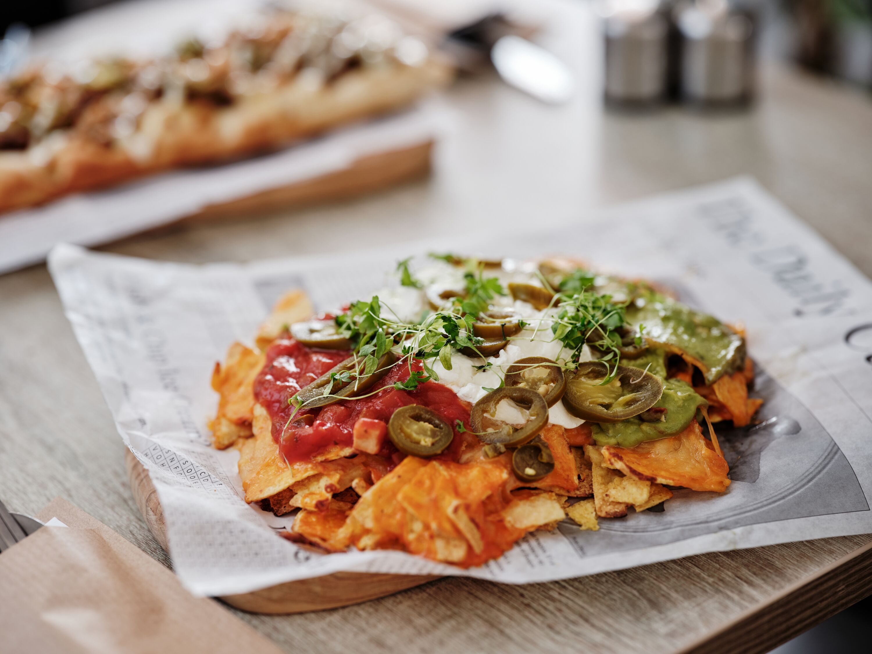 Nachos con ingredientes sobre una mesa de madera.