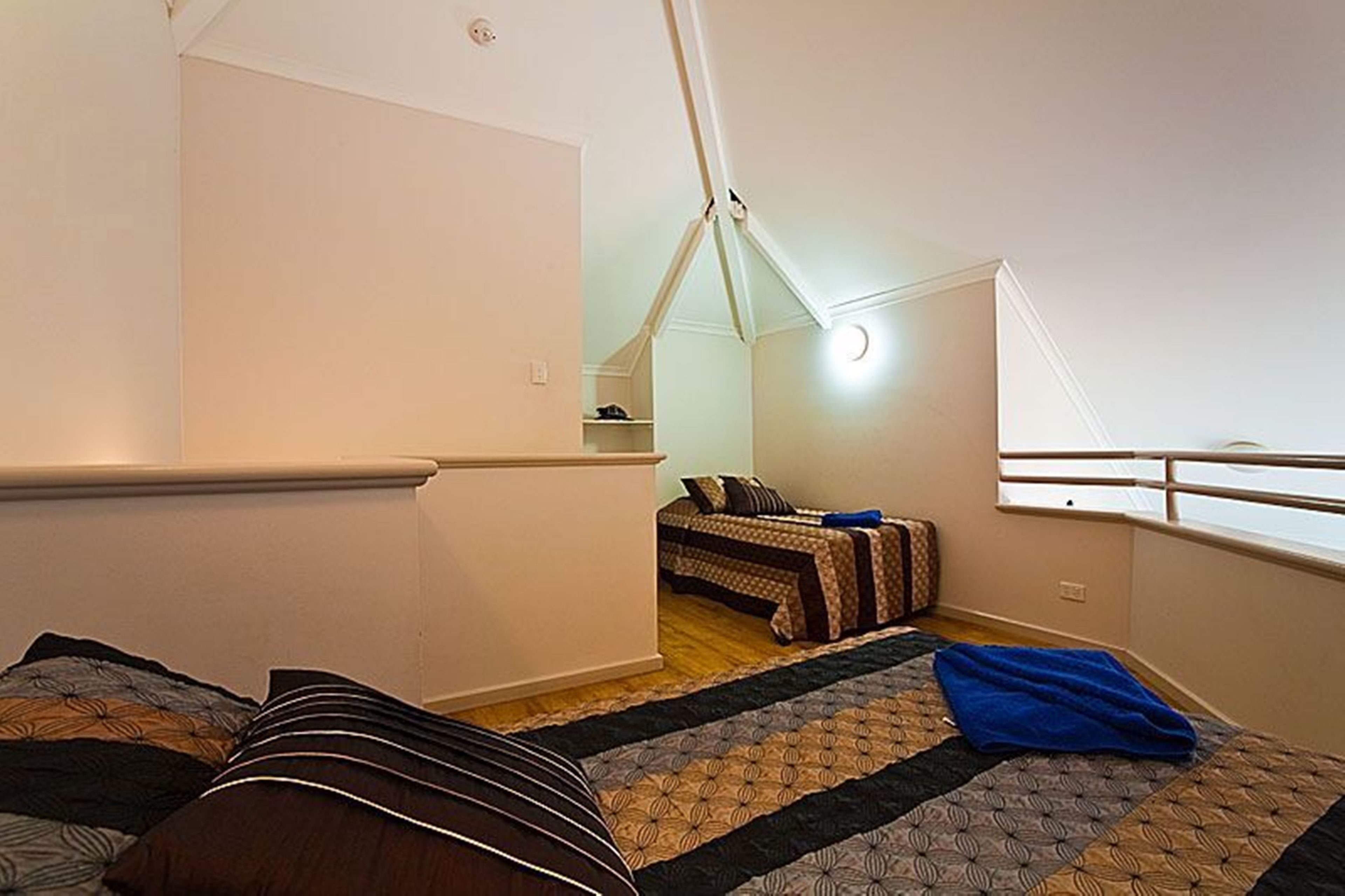 Un dormitorio con cama, ventana y un armario pequeño.