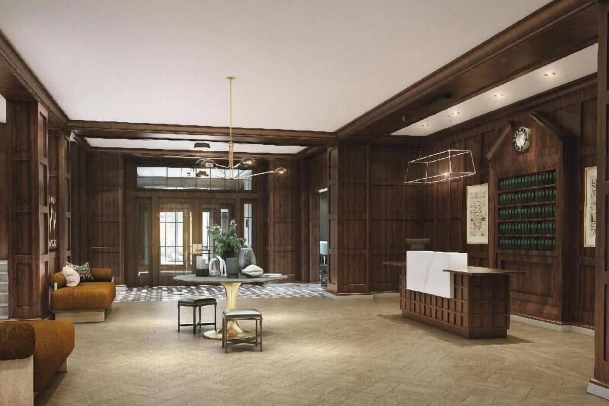 A spacious lobby with wooden paneling, a reception desk, and a seating area with a sofa and tables.