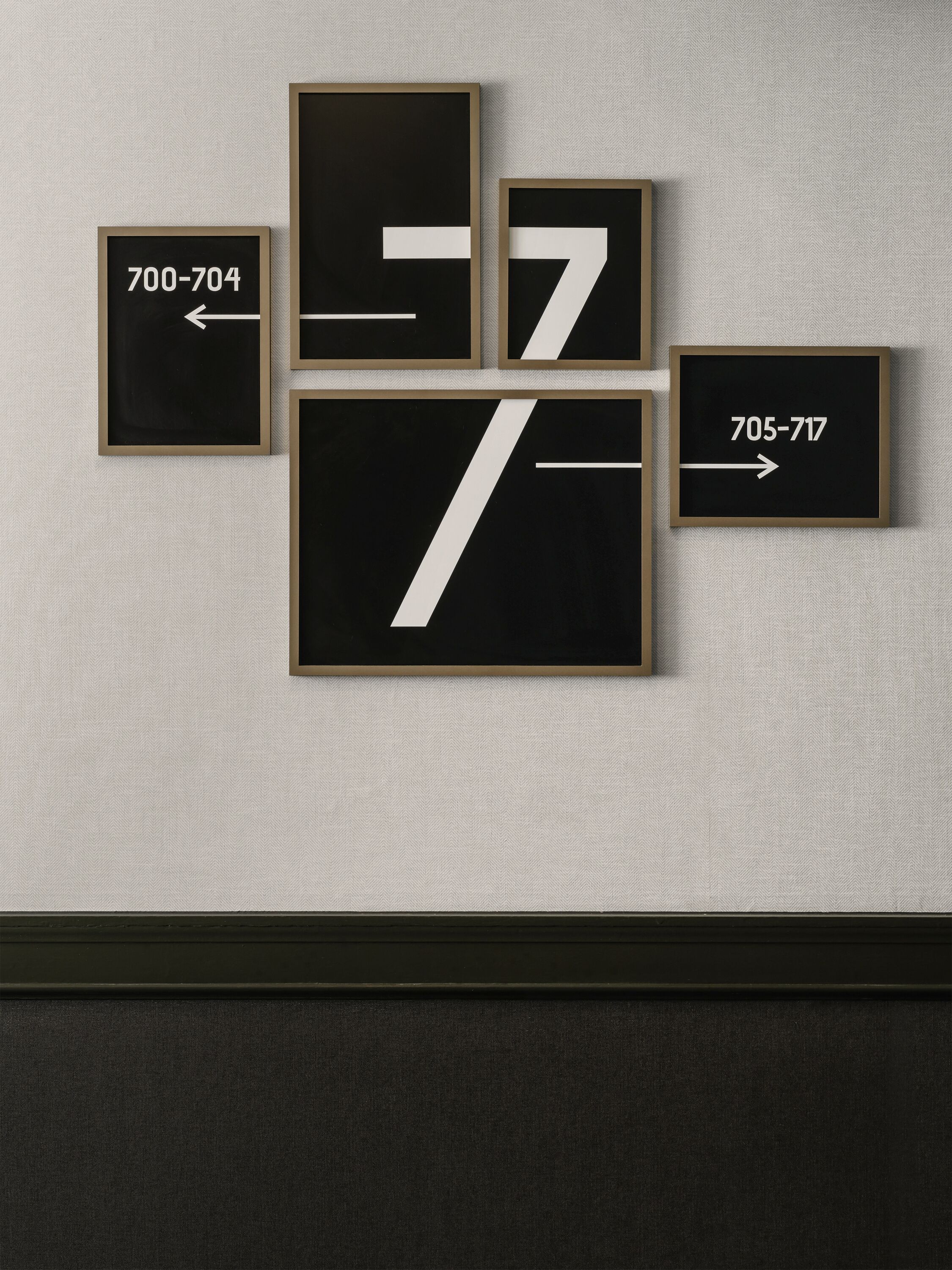 A wall with four framed signs, each displaying a number and an arrow.