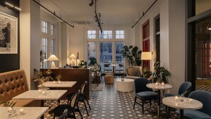 Un restaurante acogedor con diversas opciones de asientos, como cabinas y mesas, y un suelo estampado.