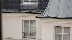 A building with multiple windows and balconies, featuring a classic architectural style with a dark roof and light walls. - Hotel Pulitzer Paris (Paris)