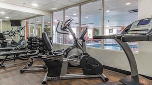 Un gimnasio con cintas de correr, bicicletas estáticas y máquinas de pesas.