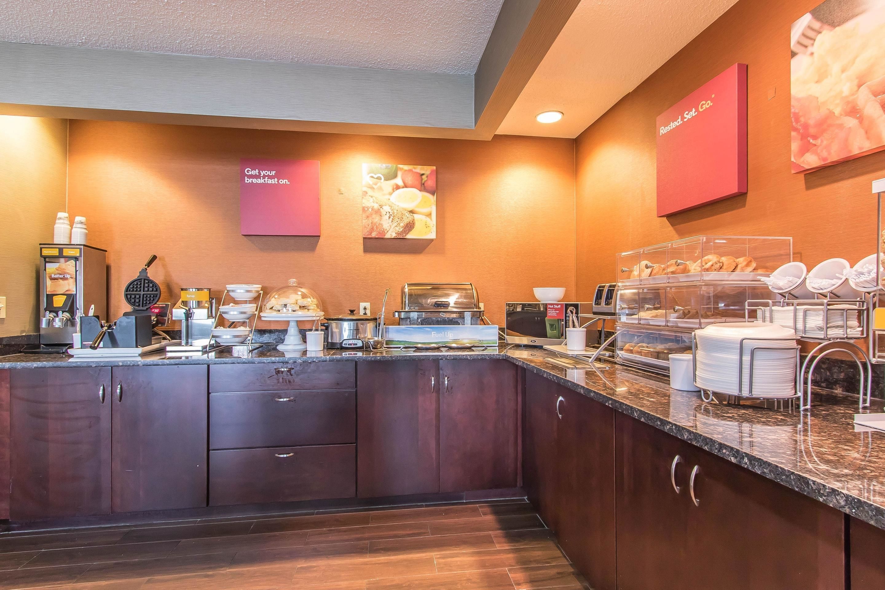 A breakfast bar with a variety of food items and a coffee machine.