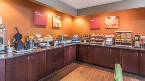 A breakfast bar with various food items and appliances, including a waffle maker, toaster, and coffee maker. - Comfort Suites Richmond (Richmond)