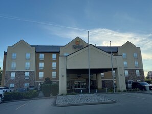 A hotel with a central entrance, multiple floors, and a parking lot. - Comfort Suites Richmond (Richmond)