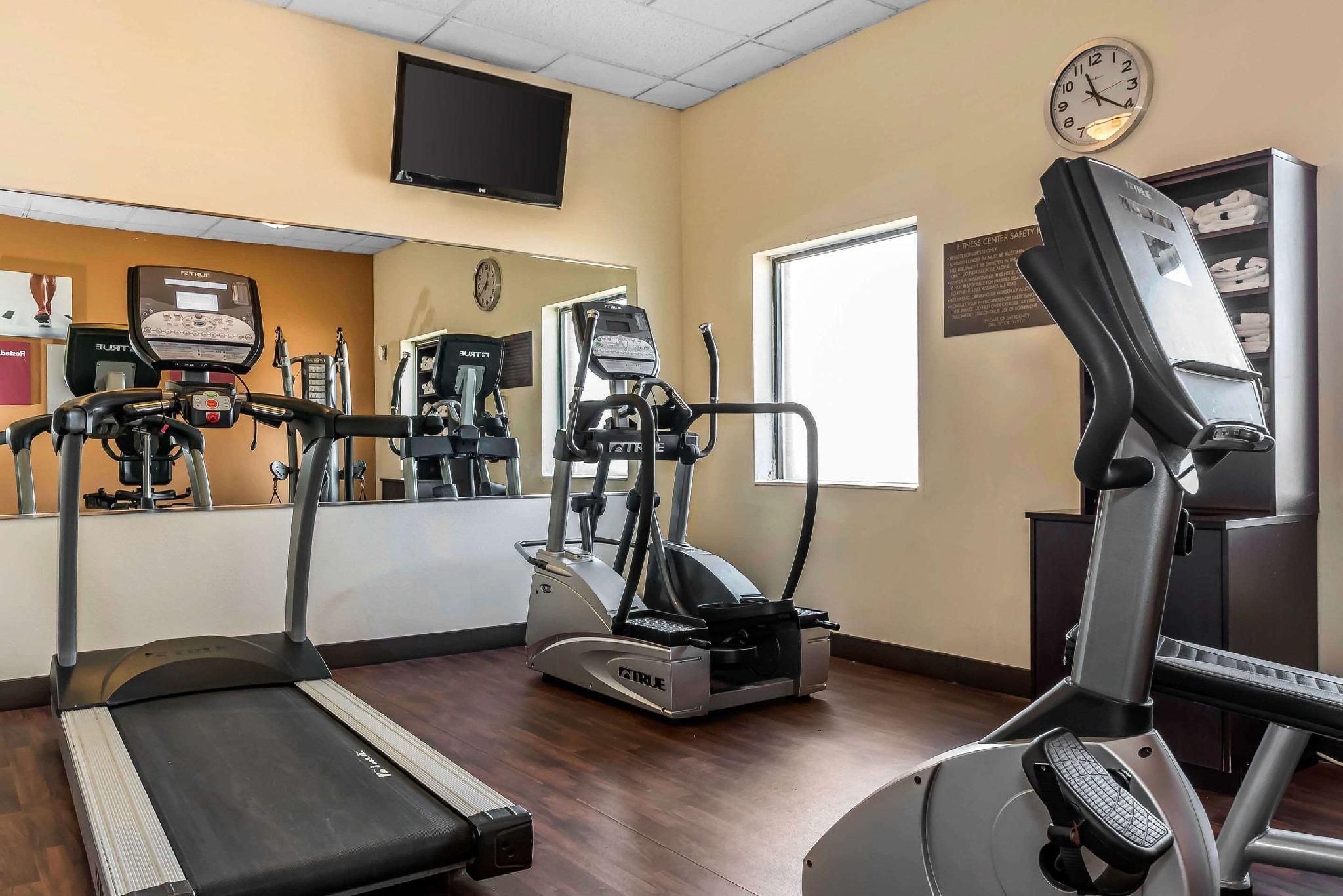 A fitness center with treadmills, elliptical machines, and a stationary bike.