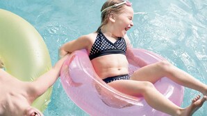 A person floating on a pink inflatable ring in a pool. - Country Inn & Suites by Radisson, Lexington, VA (Lexington)