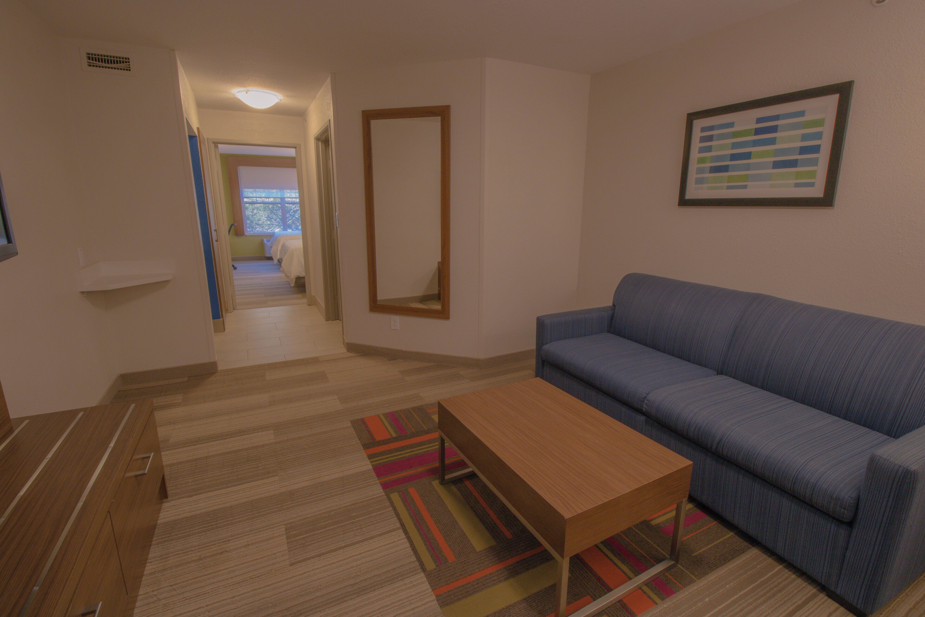 A living room with a sofa, a coffee table, and a patterned rug.