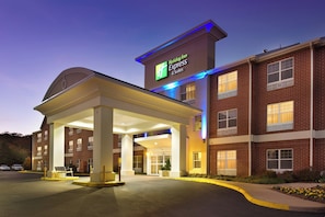 Un hôtel Holiday Inn Express & Suites doté d’un espace extérieur couvert et d’une façade en briques.
