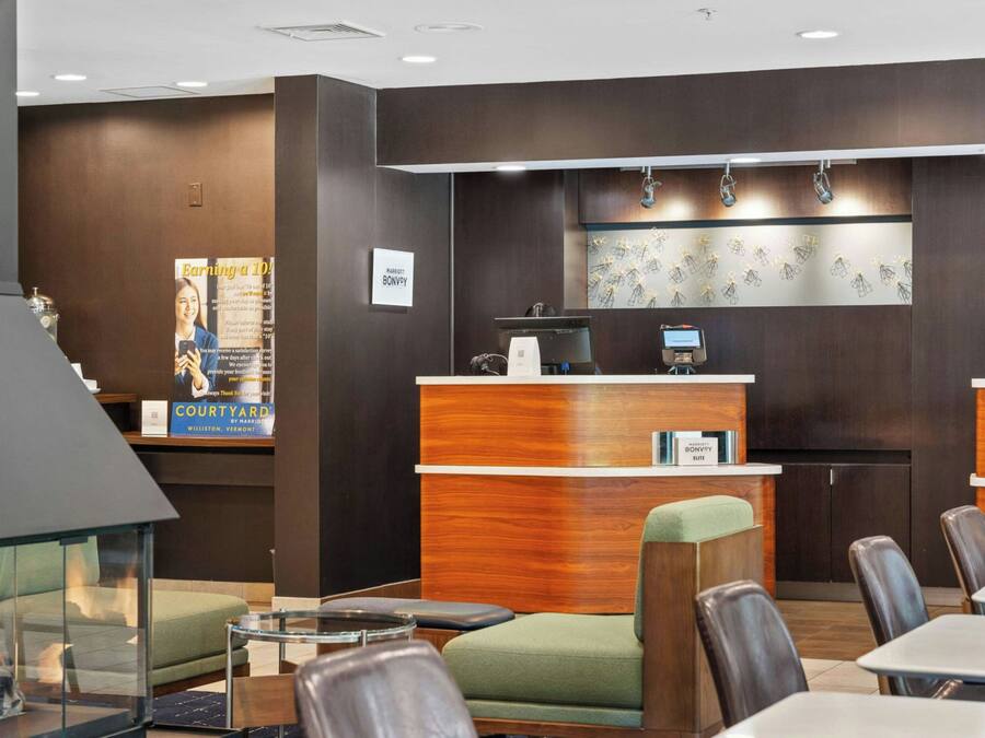 A hotel lobby with a reception desk, seating area, and a fireplace.