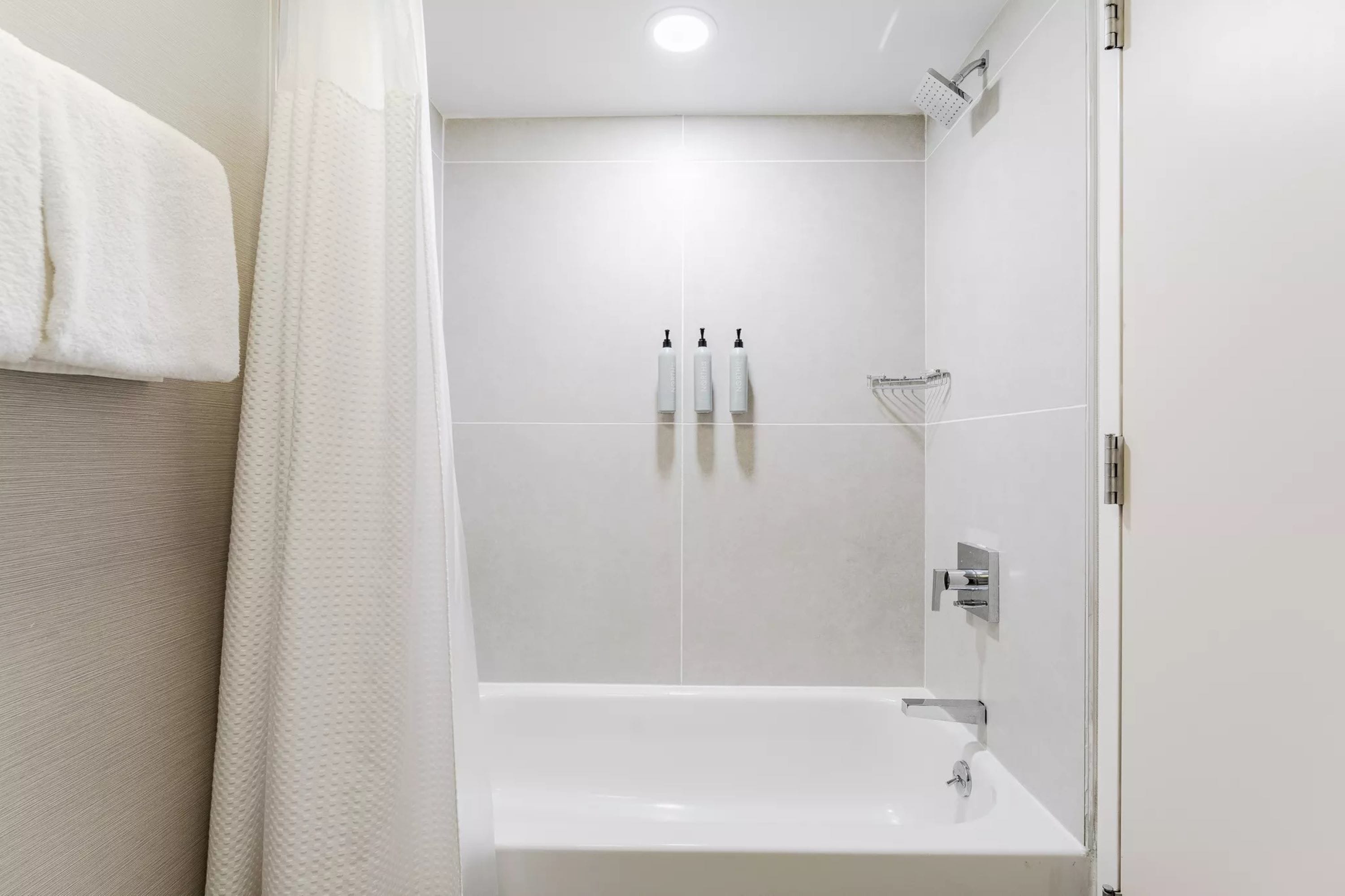 Un baño moderno con bañera, ducha y lavamanos.