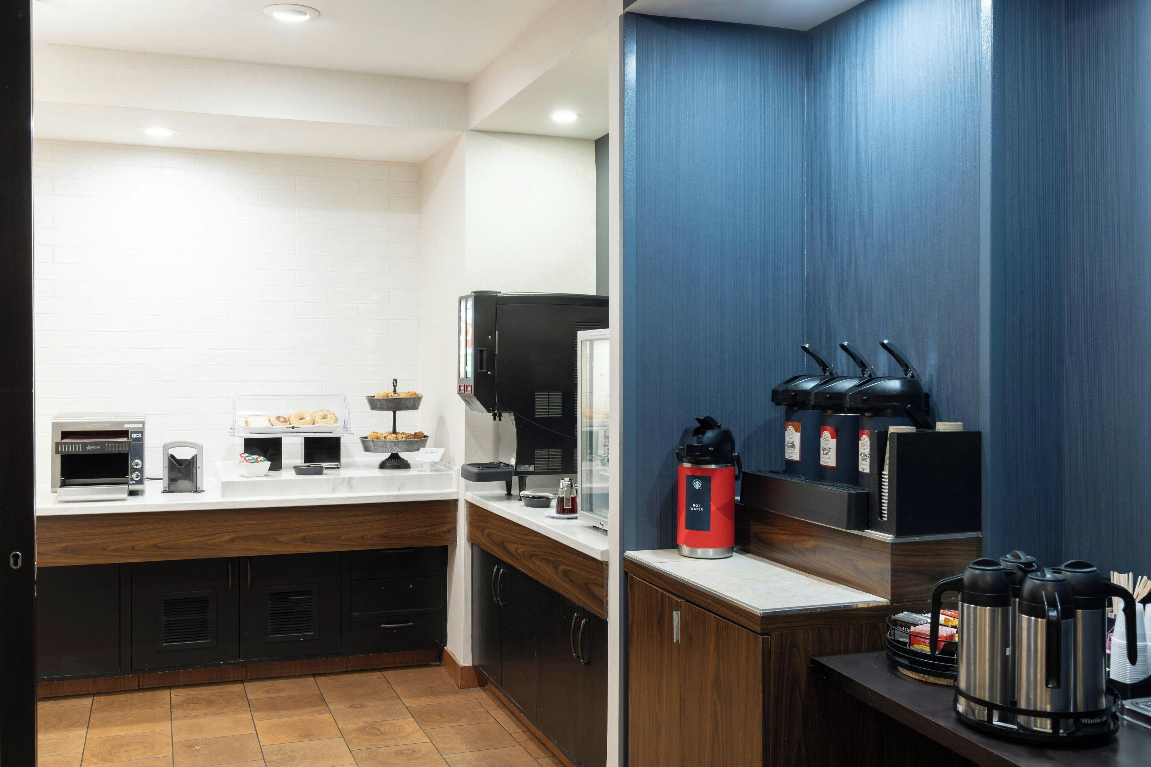 A modern kitchen with a coffee station, a toaster, and a coffee maker.