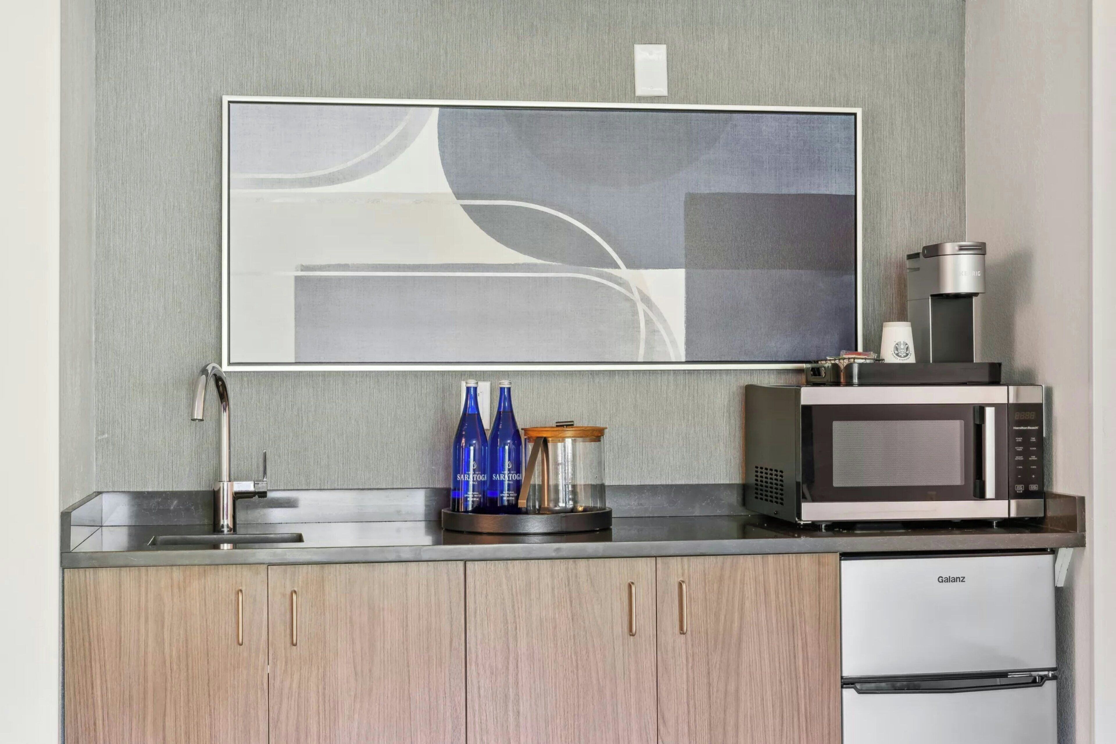 A modern kitchen with a stainless steel sink, a microwave, and a Galanz refrigerator.