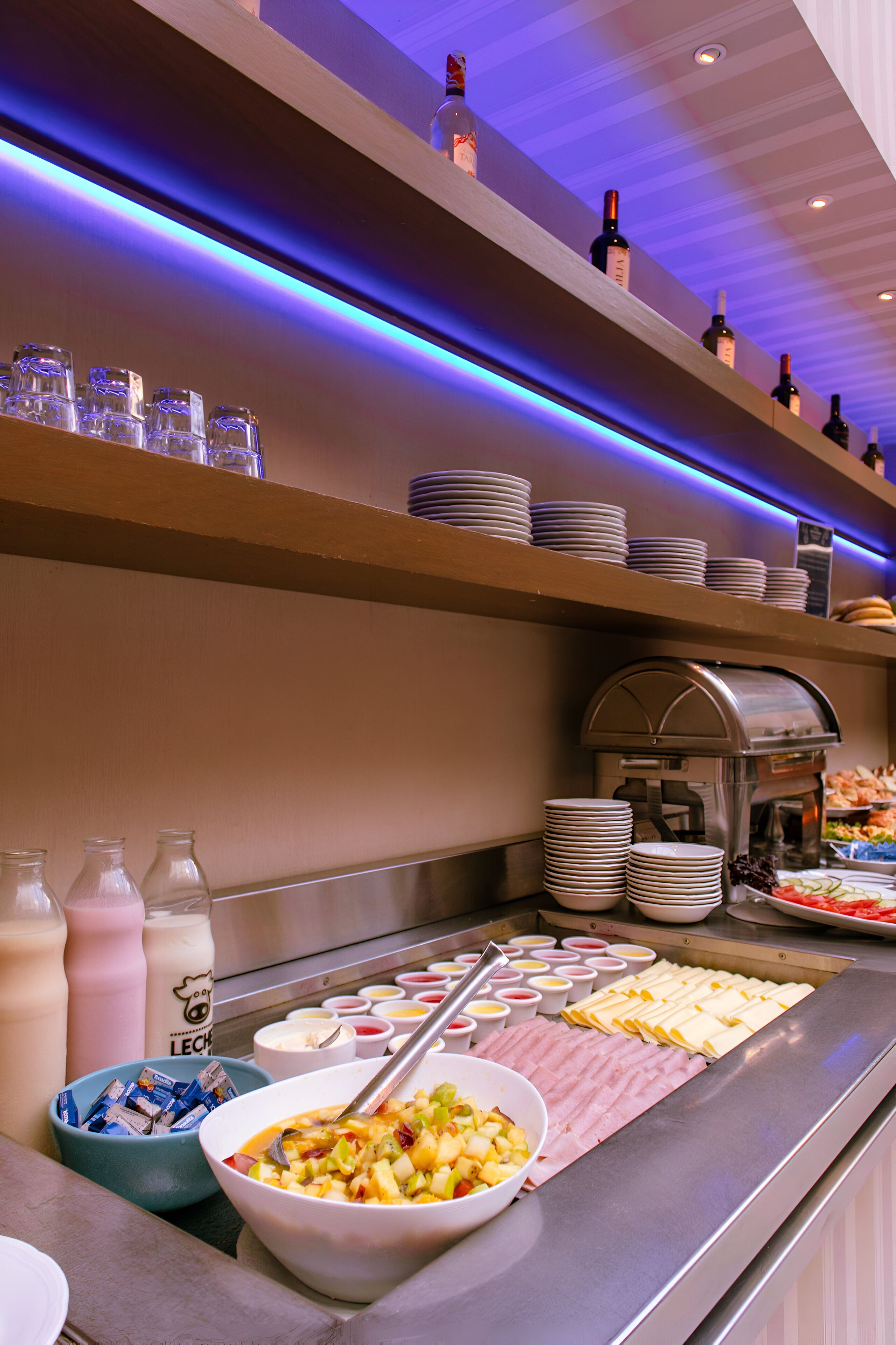 A buffet area with various food items, a coffee machine, and a selection of beverages.