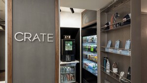 A hotel room with a minibar, a television, and a refrigerator stocked with beverages and snacks. - Courtyard by Marriott Charlottesville - University Medical Center (Charlottesville)