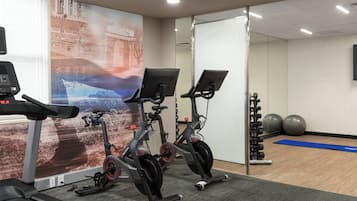 A gym with stationary bikes, a treadmill, and exercise balls.