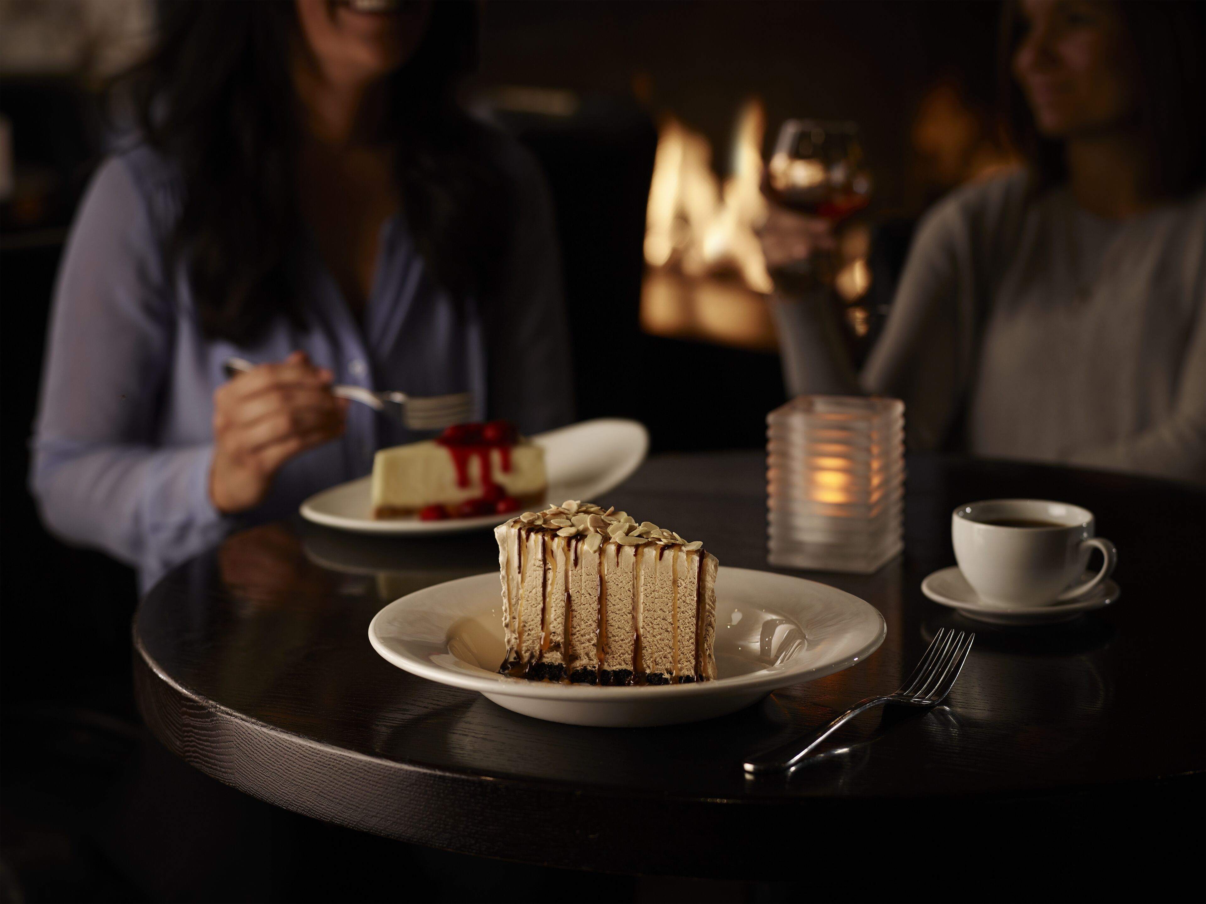 A dessert table with a slice of cake and a cup of coffee.