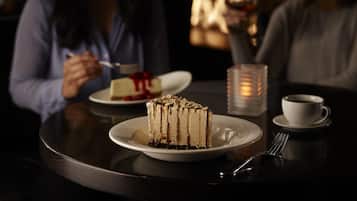 A dessert table with a slice of cake and a cup of coffee.