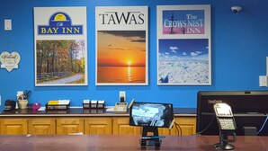 A reception desk with framed pictures of the Bay Inn, Tawas, and The Crow's Nest Inn.
