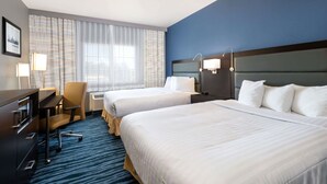A hotel room with two beds, a desk, a chair, and a large window with curtains. - Hotel 1550 - SFO Airport (San Bruno)